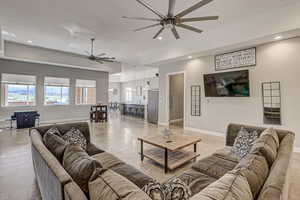 Living room with ceiling fan, concrete flooring, and recessed lighting