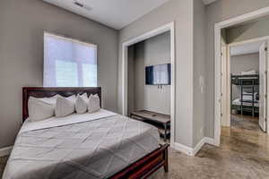 Bedroom with concrete flooring and a closet