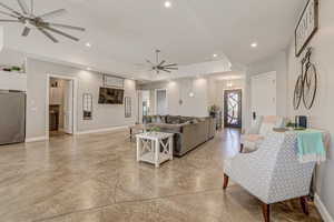 Living area featuring ceiling fan, finished concrete flooring, and recessed lighting