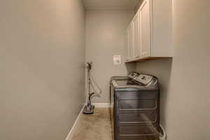 Laundry area featuring cabinet space and washer and clothes dryer