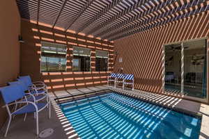 View of pool with a pergola and patio surround