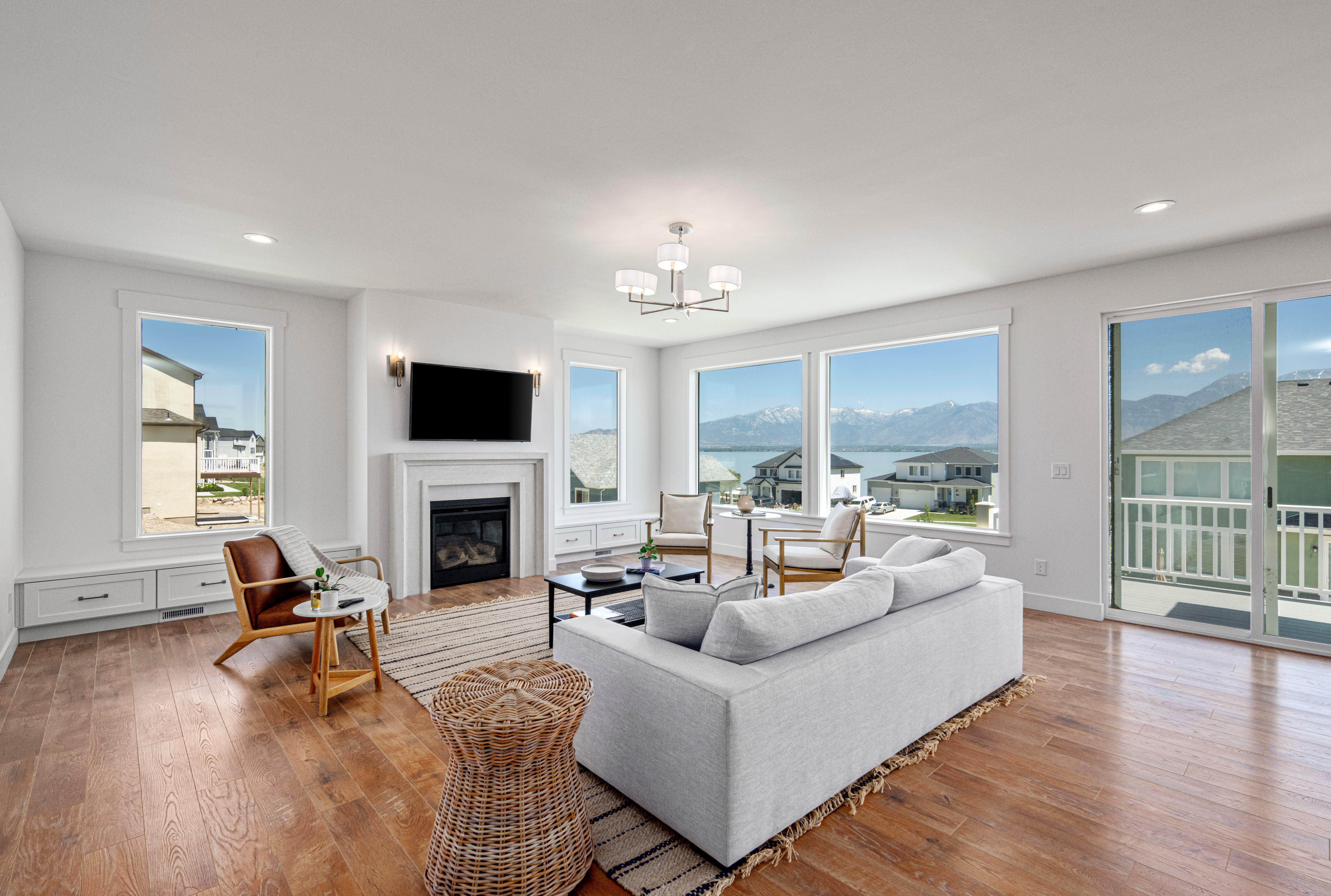 Living area with hanging lights, a glass covered fireplace, and hardwood / wood-style floors