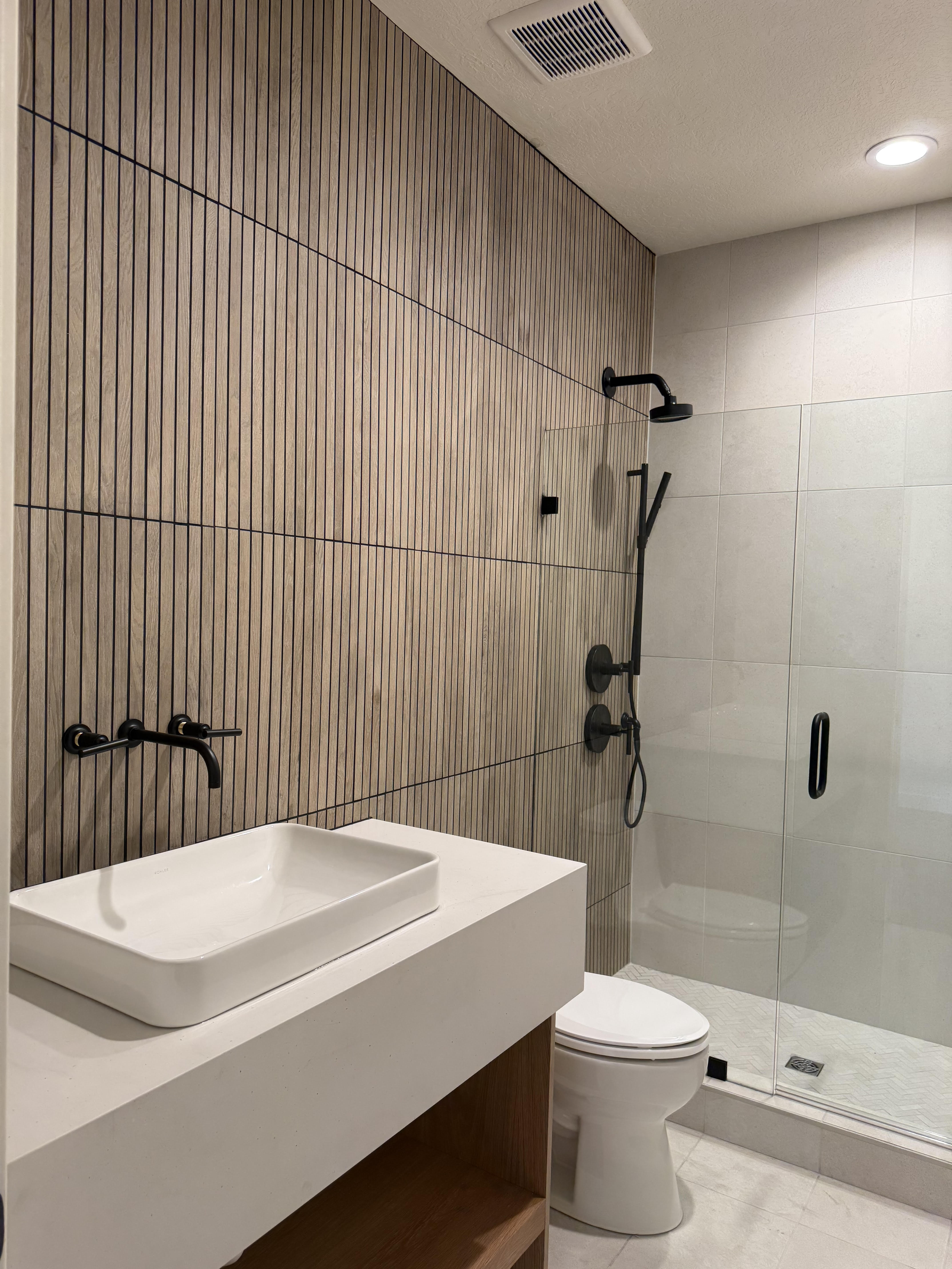 Bathroom featuring vanity, a stall shower, a textured ceiling, recessed lighting, and tile walls