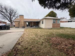 Back of property with brick siding, a patio, a chimney, and crawl space