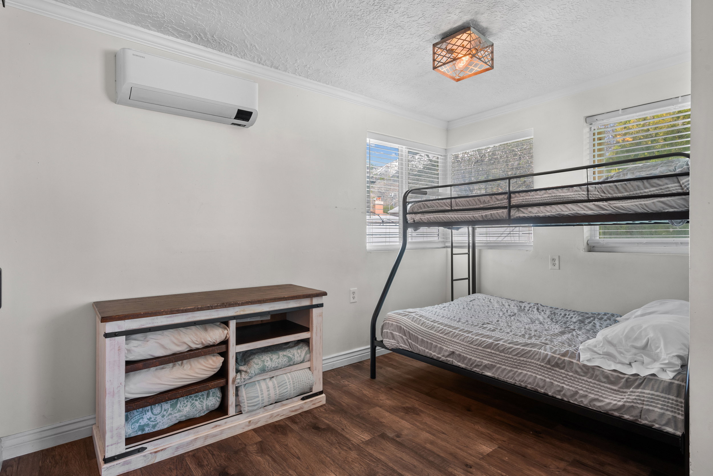 Interior space featuring wood-finish flooring, a wall-mounted mini-split system, and a ceiling-mounted light fixture