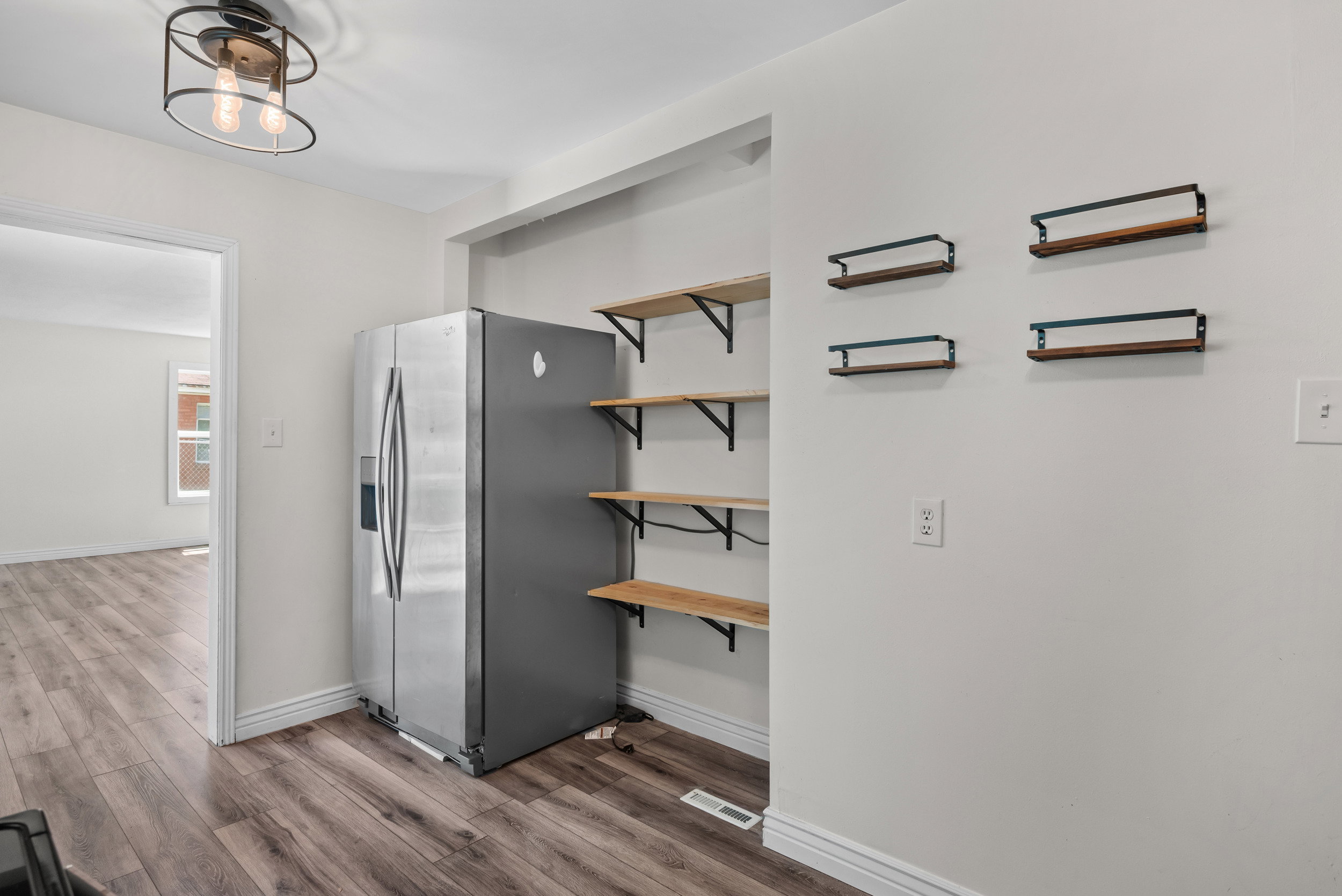 Kitchen area featuring wood-finish flooring, built-in shelving, and a modern semi-flush mount ceiling fixture