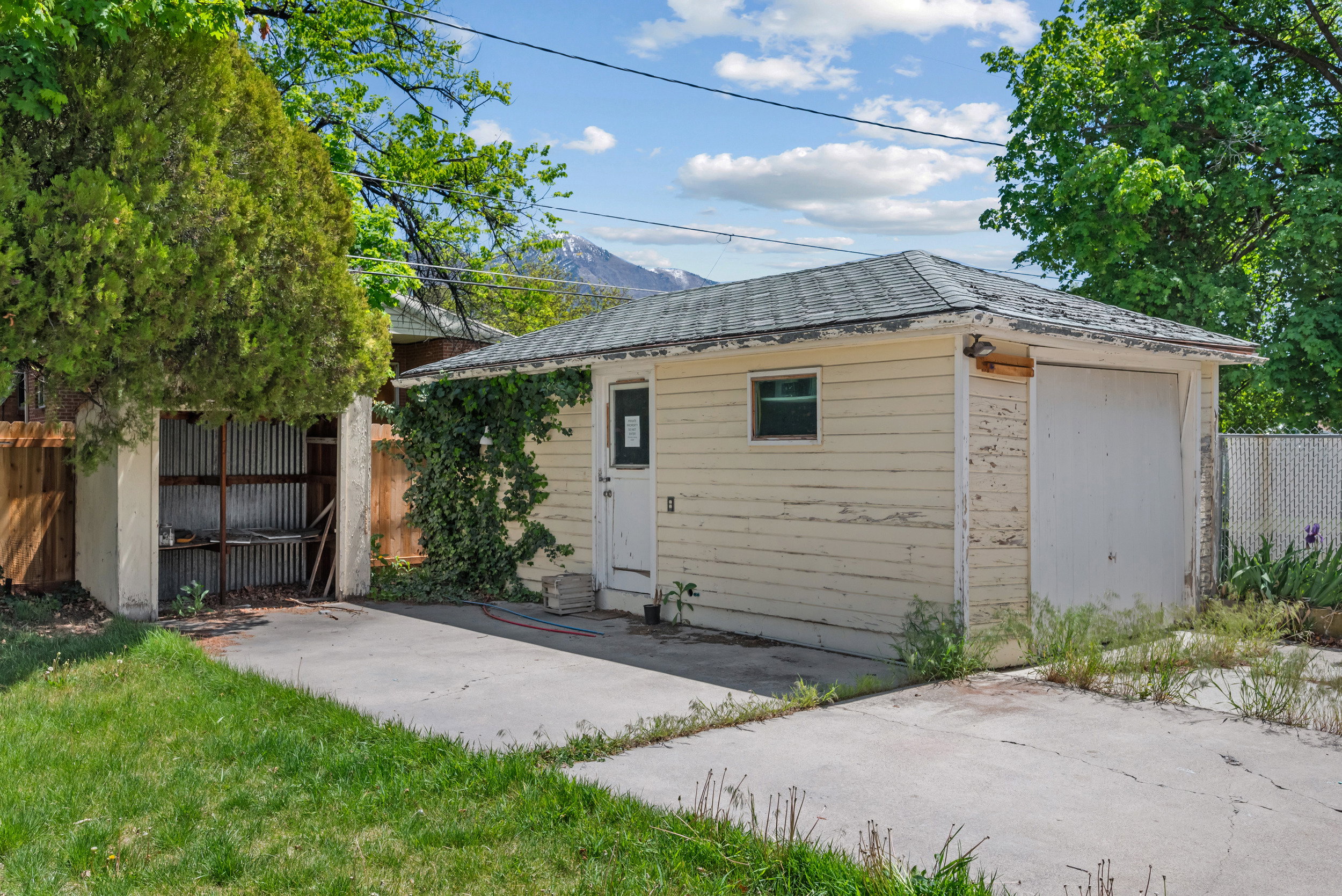 Detached garage structure featuring a single garage door, side entrance, and small window