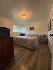 Bedroom featuring dark wood-style floors and baseboards