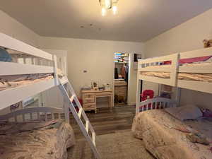 Bedroom with dark wood-style floors and a closet