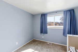 Spare room with baseboards and light colored carpet