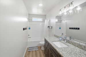 Bathroom featuring vanity, light wood-style flooring, and shower / bathtub combination with curtain
