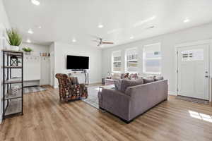 Living room featuring light wood-style flooring, a ceiling fan, and recessed lighting