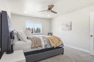 Bedroom with light colored carpet and a ceiling fan