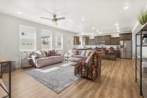 Living room featuring ceiling fan, light wood-type flooring, and recessed lighting