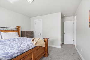 Bedroom featuring light carpet and baseboards