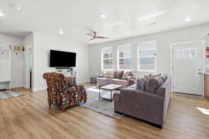 Living room featuring light wood-style floors, a ceiling fan, and recessed lighting