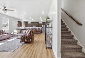 Living room featuring light wood-style flooring, recessed lighting, and a ceiling fan
