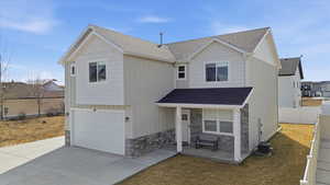 View of front of property with a shingled roof, an attached garage, stone siding, and a porch