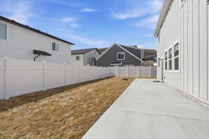 Fenced backyard featuring a patio area and a residential view