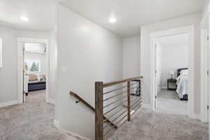 Hall with an upstairs landing and light carpet
