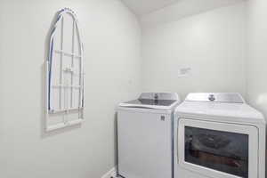Laundry area with separate washer and dryer and vaulted ceiling