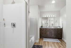 Bathroom featuring vanity, light wood finished floors, a shower, and a bathtub
