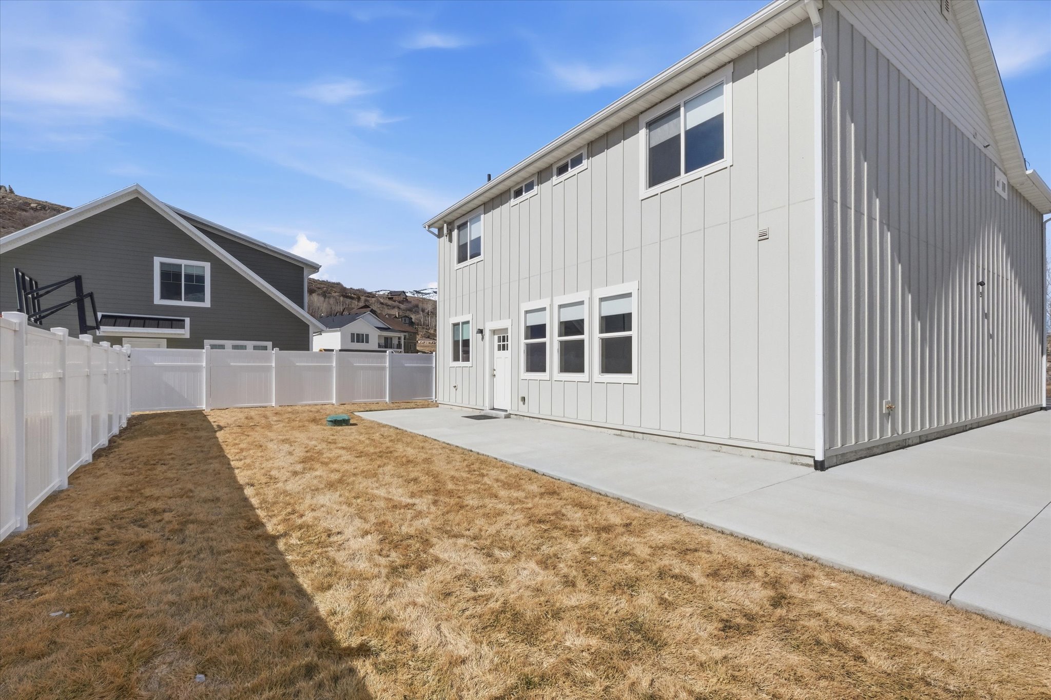 Back of property featuring board and batten siding and a fenced backyard