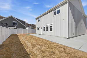 Back of property featuring board and batten siding and a fenced backyard