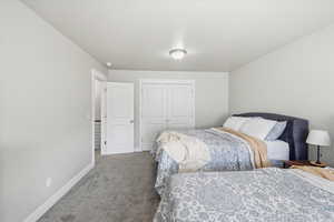 Carpeted bedroom featuring baseboards and a closet