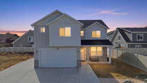 View of front of house with stone siding, an attached garage, board and batten siding, and driveway