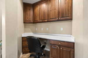 Home office with built in desk and baseboards