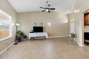 Living area with a ceiling fan and vaulted ceiling