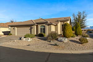 View of front of house with stucco siding, a garage, concrete driveway, a tile roof, and a mountain view