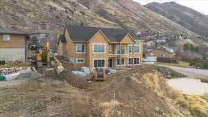 View of back facade, mountain view, and a covered patio area