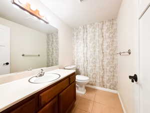Full bath featuring vanity, light tile patterned floors, and a shower with shower curtain