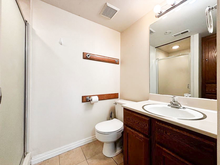 Full bath with a stall shower, vanity, and light tile patterned floors