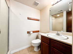 Full bath with a stall shower, vanity, and light tile patterned floors