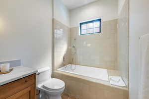 Bathroom with tiled shower / bath, vanity, and tile patterned floors