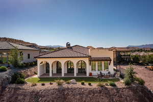 Rear view of house featuring a patio, a mountain view, stucco siding, and a fire pit