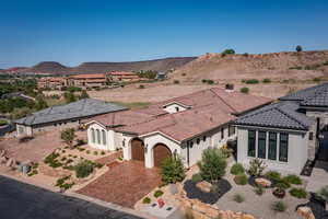 View of front of property featuring stucco siding, a garage, driveway, a mountain view, and a tile roof