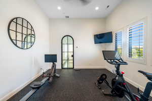 Workout room featuring dark rubber floors and recessed lighting