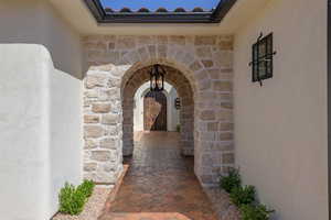 Mediterranean-style portico featuring arched walkways and a chandelier