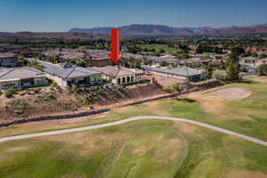 Aerial view of residential area with a mountainous background and a golf club
