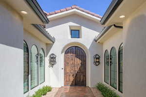Doorway to property featuring a tiled roof and stucco siding