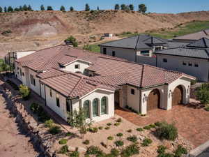 View of front of house with an attached garage, driveway, stucco siding, and a tile roof