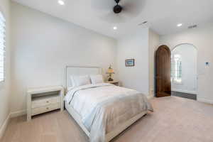 Bedroom with light colored carpet, ceiling fan, and recessed lighting