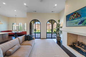 Living room with a fireplace, dark wood-style flooring, and recessed lighting