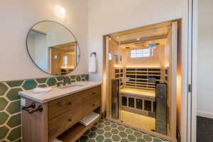 Bathroom with a sauna / steam room, vanity, and tasteful backsplash