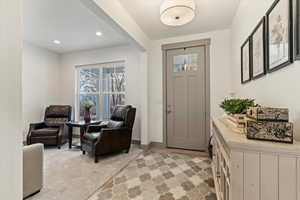 Entrance foyer with recessed lighting and light carpet
