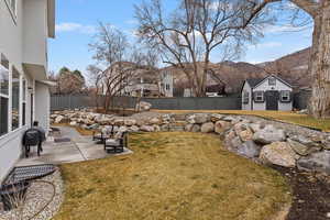 Fenced backyard featuring a patio, an outbuilding, and a mountain view